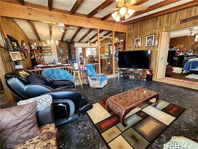 living room featuring a wood stove, beam ceiling, ceiling fan, and wooden walls