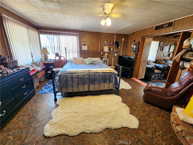 bedroom featuring wood walls and ceiling fan