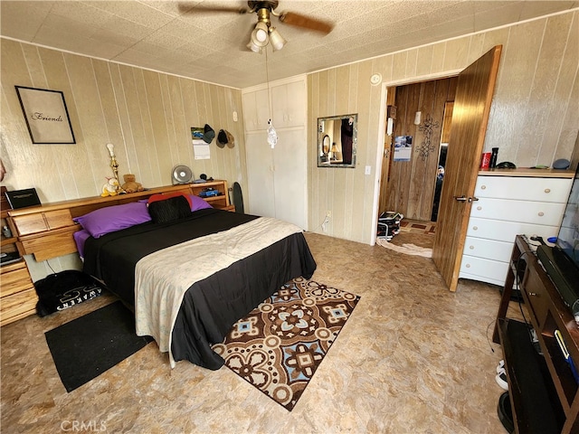 bedroom featuring wood walls and ceiling fan