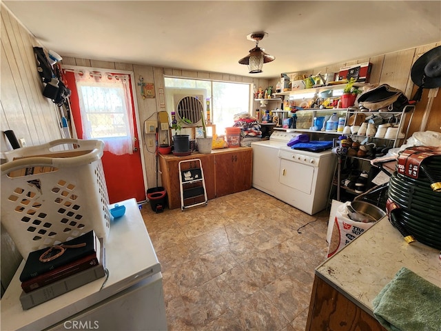 kitchen featuring wood walls, washing machine and clothes dryer, and a wealth of natural light