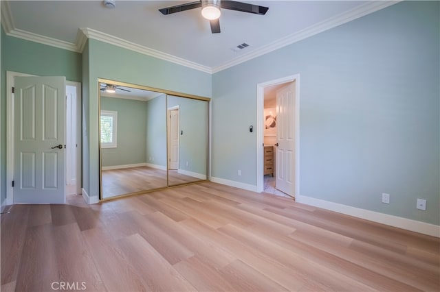 unfurnished bedroom with ensuite bathroom, light hardwood / wood-style flooring, ornamental molding, ceiling fan, and a closet