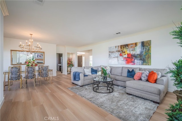 living room with an inviting chandelier, hardwood / wood-style flooring, and crown molding