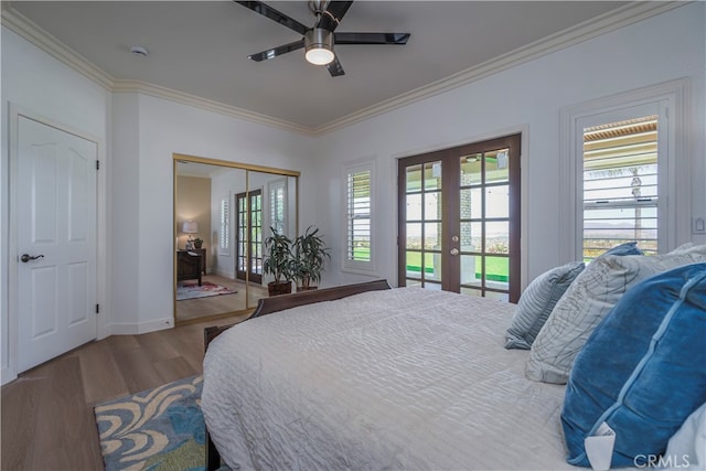 bedroom featuring french doors, crown molding, multiple windows, and hardwood / wood-style flooring