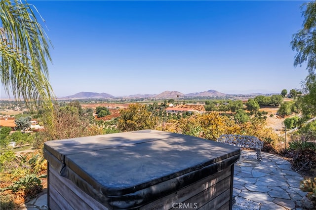 view of yard with a hot tub, a mountain view, and a patio area