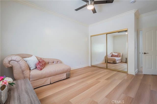 living room with hardwood / wood-style flooring, ceiling fan, and crown molding