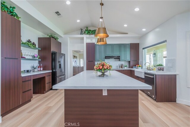 kitchen featuring decorative light fixtures, high end black refrigerator, stainless steel dishwasher, and light hardwood / wood-style floors