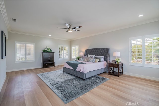 bedroom featuring ornamental molding, multiple windows, and light wood-type flooring