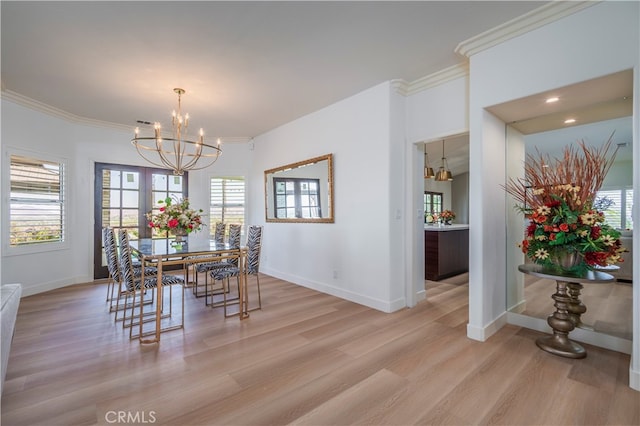 dining room with ornamental molding, light hardwood / wood-style floors, and a chandelier