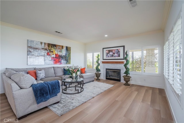 living room with ornamental molding and light hardwood / wood-style floors