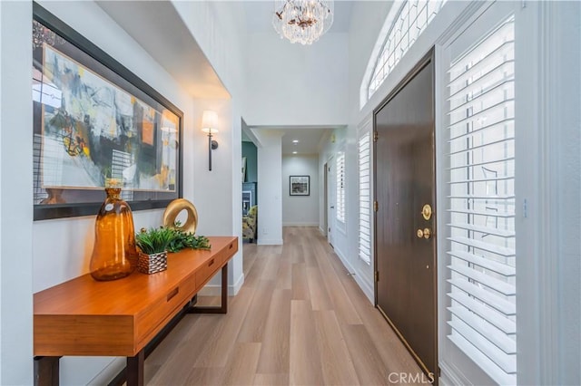 hallway featuring a notable chandelier and light wood-type flooring