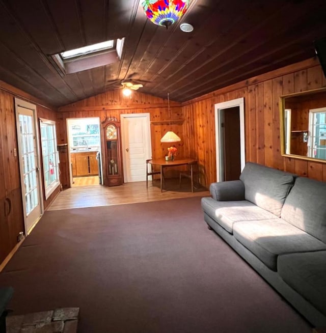 living room with wood ceiling, lofted ceiling with skylight, ceiling fan, and carpet