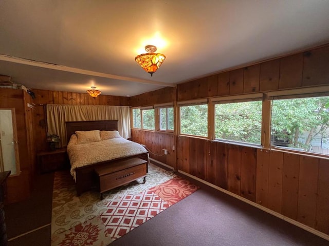 bedroom with wooden walls and carpet