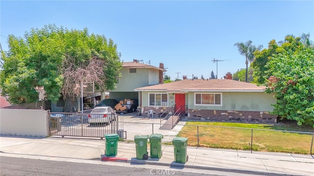 view of front of property with stucco siding, fence private yard, and concrete driveway