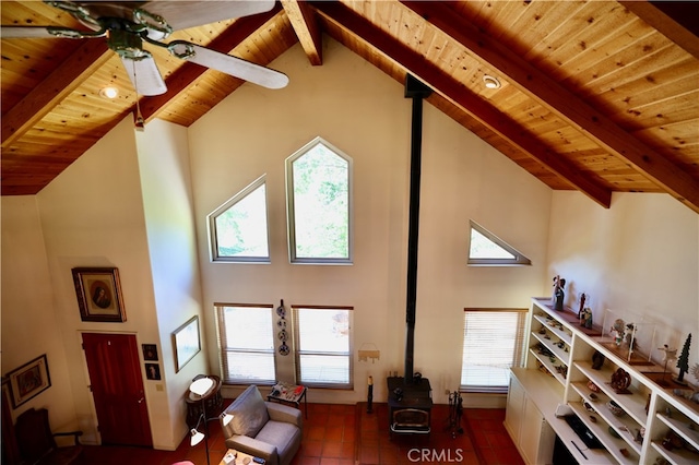 living room with wooden ceiling, beamed ceiling, a wood stove, and high vaulted ceiling