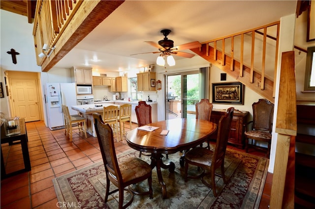 tiled dining space with ceiling fan