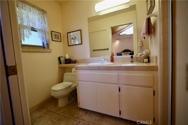 bathroom with vanity, tile patterned flooring, and toilet