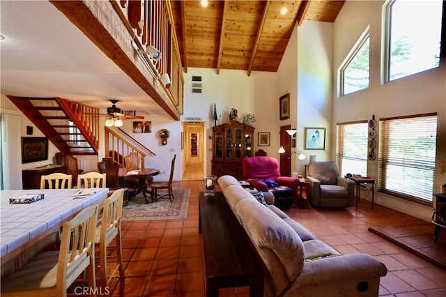 living room with dark tile patterned flooring, wood ceiling, beamed ceiling, high vaulted ceiling, and ceiling fan