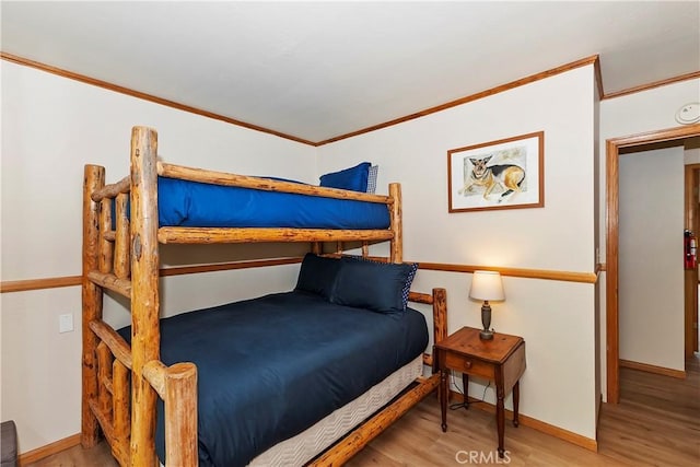 bedroom with ornamental molding and light hardwood / wood-style floors