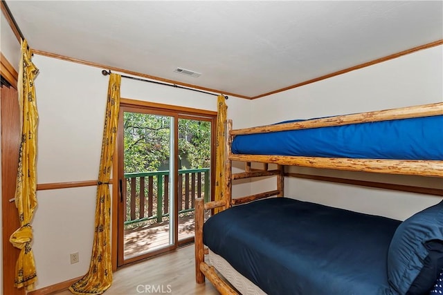 bedroom with ornamental molding, access to outside, and light wood-type flooring