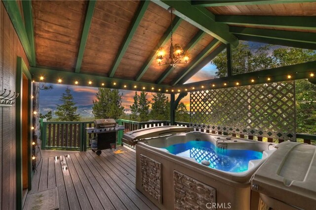 deck at dusk featuring area for grilling and a hot tub