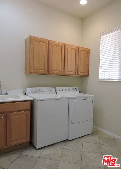 laundry room with sink, independent washer and dryer, light tile patterned floors, and cabinets