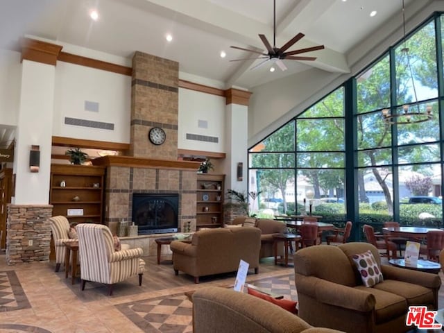 tiled living room featuring beam ceiling, a fireplace, a towering ceiling, and plenty of natural light