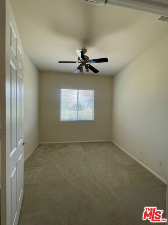 empty room featuring carpet flooring and ceiling fan