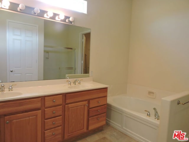 bathroom featuring vanity, shower with separate bathtub, and a skylight