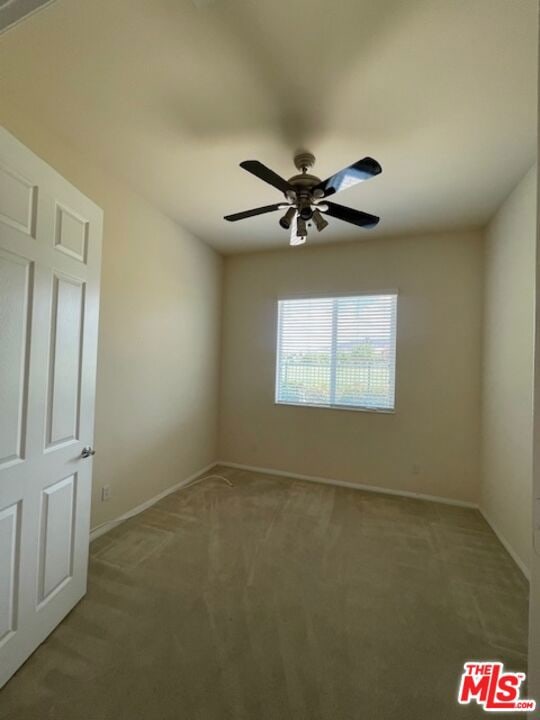 empty room with ceiling fan and carpet