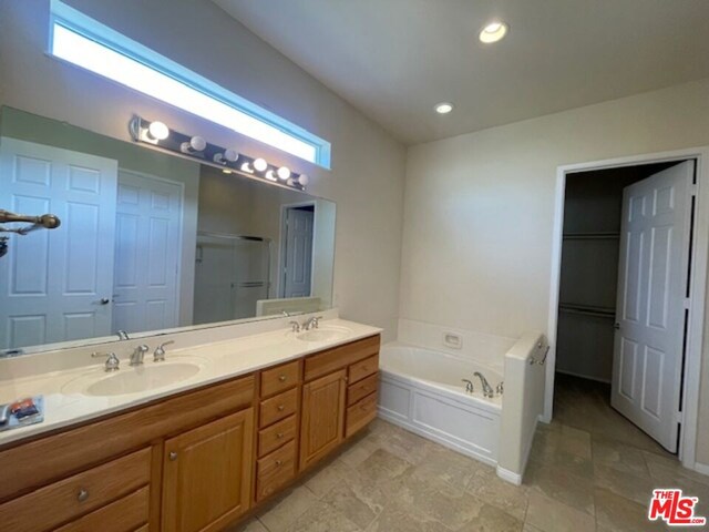 bathroom featuring vanity and separate shower and tub