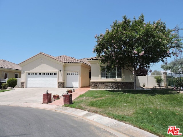 mediterranean / spanish house with a front yard and a garage