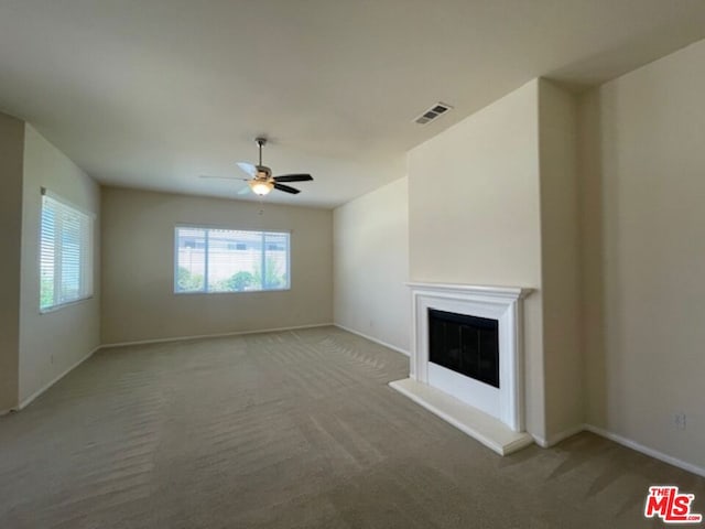 unfurnished living room with ceiling fan and carpet flooring