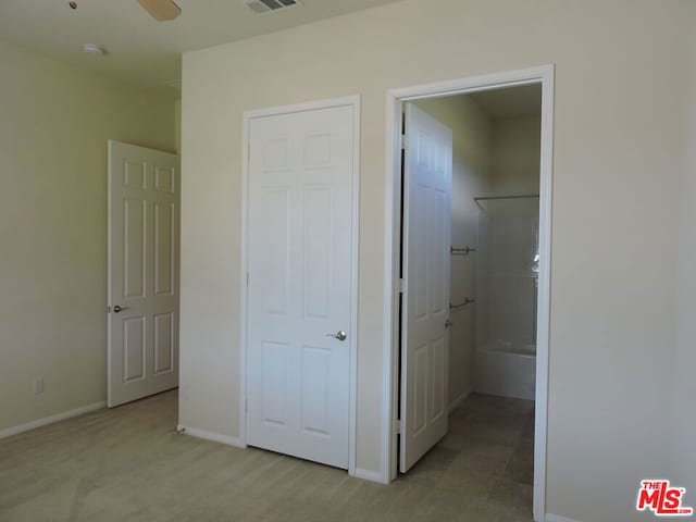 unfurnished bedroom with ensuite bath and light carpet