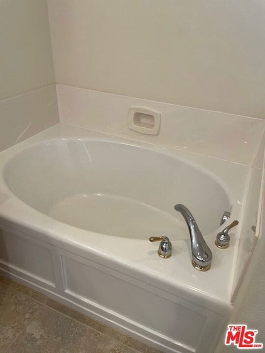 bathroom with tile patterned floors and a bathtub