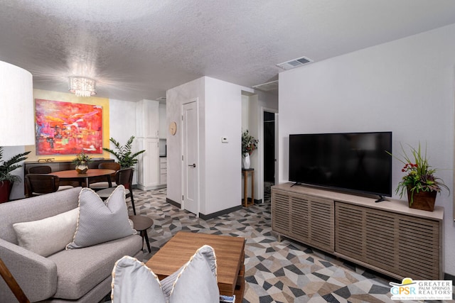 living room with a textured ceiling and a chandelier