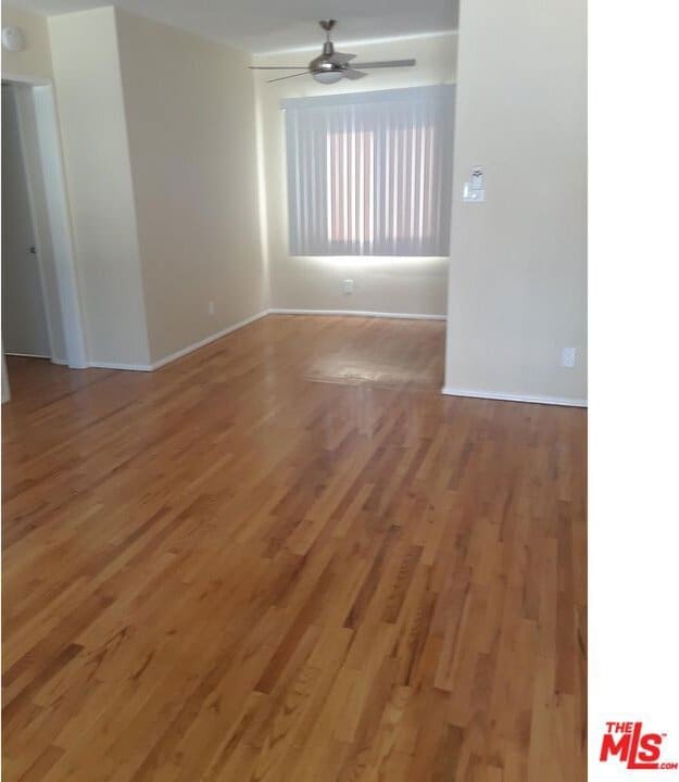 empty room featuring ceiling fan and hardwood / wood-style floors