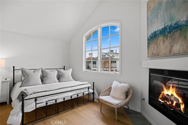 bedroom featuring light hardwood / wood-style floors and lofted ceiling