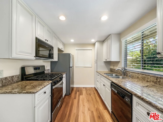 kitchen featuring white cabinets, light wood-type flooring, sink, and black appliances