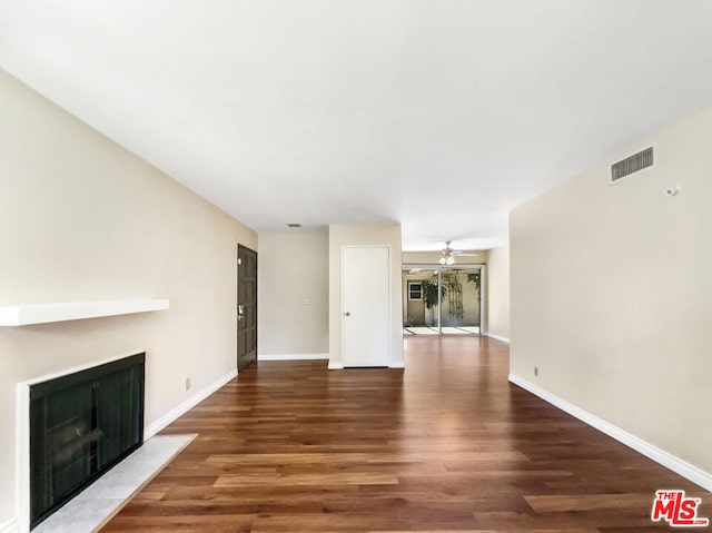 unfurnished living room with dark hardwood / wood-style floors and ceiling fan