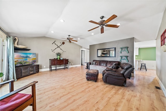 living room with ceiling fan, light wood-type flooring, and vaulted ceiling