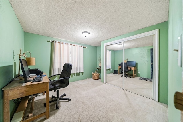 carpeted home office featuring a textured ceiling