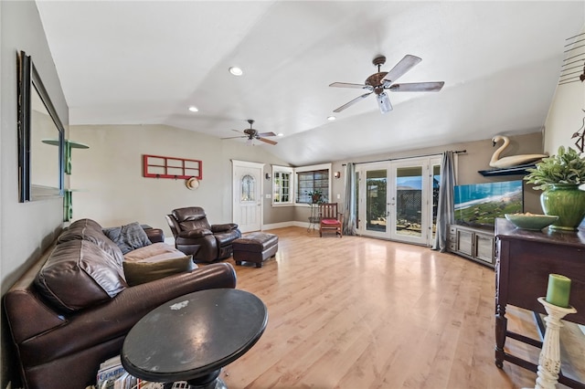 living room featuring lofted ceiling, french doors, and light hardwood / wood-style flooring