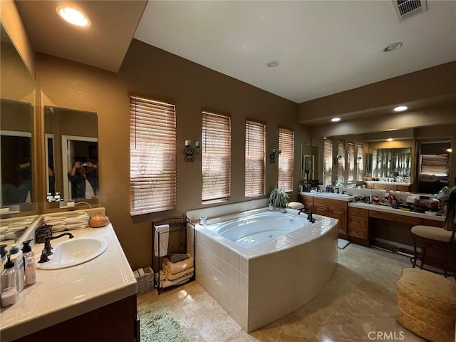 bathroom with vanity and a relaxing tiled tub