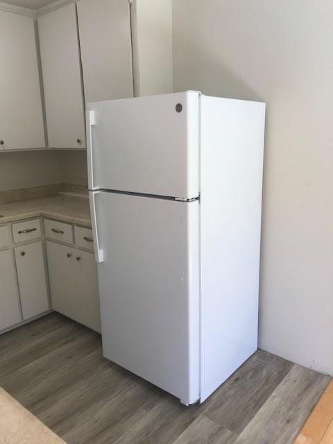 kitchen featuring white refrigerator, white cabinets, and light hardwood / wood-style floors