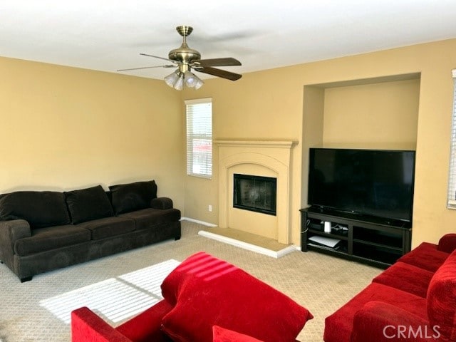 carpeted living room with ceiling fan