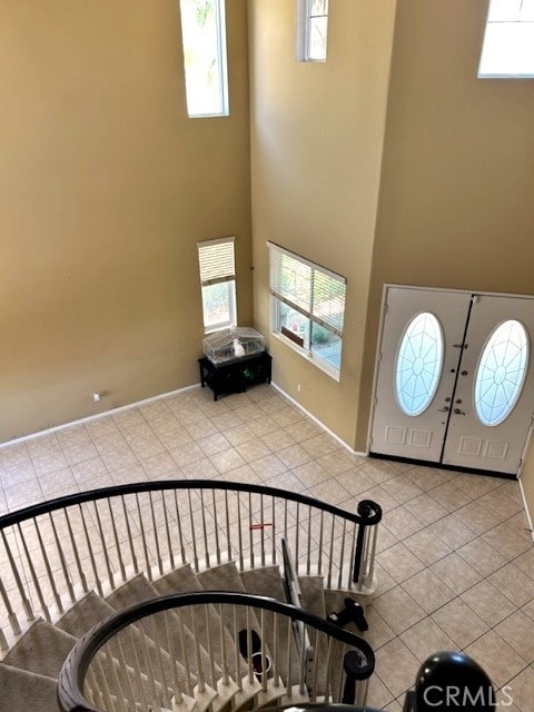 tiled foyer entrance with a towering ceiling