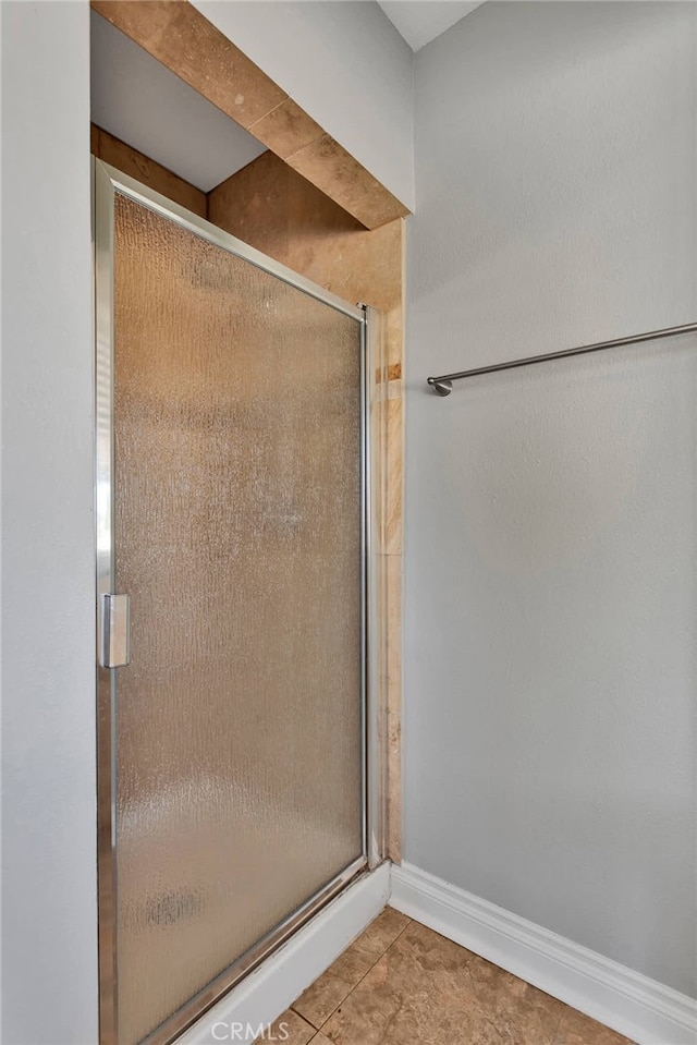 bathroom with walk in shower and tile patterned flooring