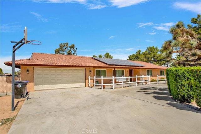 ranch-style house featuring solar panels and a garage