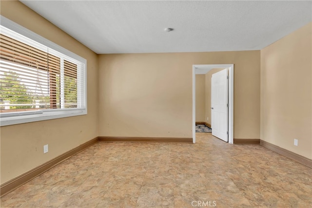 unfurnished room featuring a textured ceiling