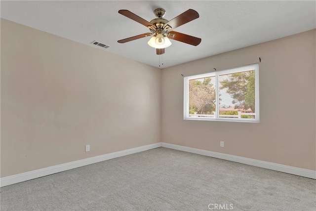 unfurnished room with a textured ceiling, ceiling fan, and light colored carpet